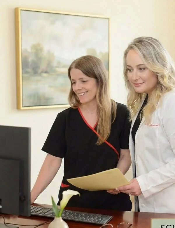 Dr. Marina Gafanovich reviewing immigration medical exam paperwork with a staff member in her Upper East Side office
